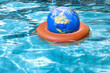 © Designpics - Globe in Life Preserver in Pool