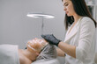 © Anna - Cosmetologist and dermatologist makes a moisturizing, rejuvenating woman lying patient in a beauty salon.