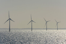 Offshore Wind Turbine Farm With Sun Shining On The North Sea On A Hazy Morning, United Kingdom