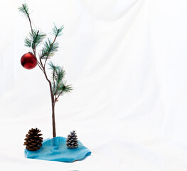 small christmas tree with one red ornament on a white background as in a charlie brown christmas