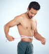 Man, body or measuring tape on waist on studio background for weight loss management, fat control or bmi and diet wellness. Fitness model, sports athlete or coach with tape measure for muscle goals