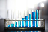 Fototapeta Tęcza - Test tube with blue liquid on the laboratory table. Examination of liquid under a microscope.
