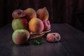 Wall Mural - Still life of fresh peaches and apples on a dark background.