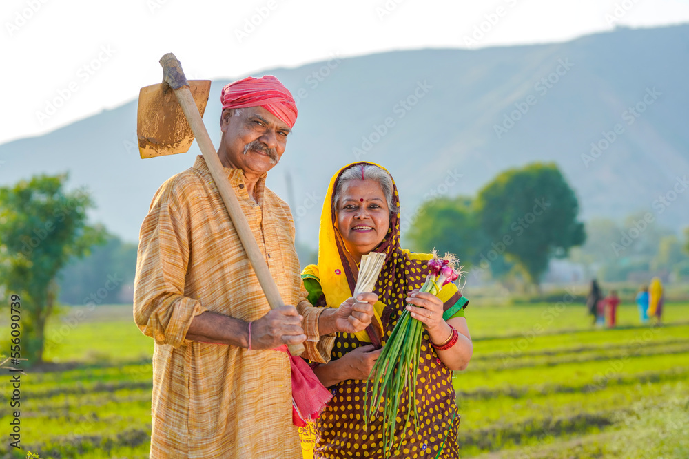 Indian farmer couple standing at agriculture field and showing rupees ...