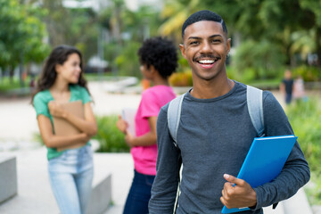 Smart african american male student with group of brazilian female young adults