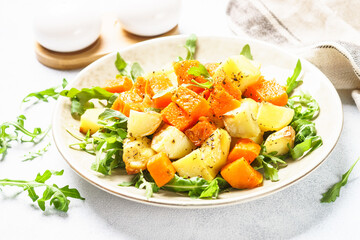 Warm salad with pumpkin, potato and arugula.