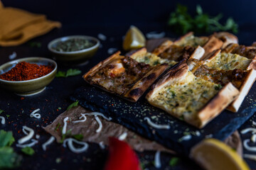 Wall Mural - Turkish pide pastry baked in a stone oven served on stone plate with minced meat and cheese