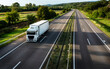 © Ivan - White truck driving on the highway winding through forested landscape in autumn colors at sunset