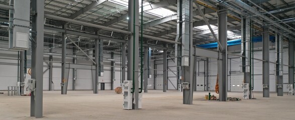 Newly built empty production hall of a medical enterprise before the installation of production equipment. A frame building made of metal and glass from the inside with all communications installed.