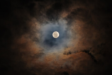 Wall Mural - The Moon in the night sky is surrounded by beautiful colorful clouds. Corona (plural coronae) is an optical phenomenon produced by the diffraction of moonlight
