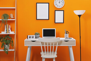 Workplace with laptop, stationery on desk and chair in home office