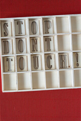 Sticker - stop dont touch! in a shallow box with boxy compartments