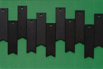 Poster - black chalk banner tags arranged in a row on dark green corrugated paper