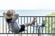 © Chinnapong - Worl-life balance, relaxation healthy quality living lifestyle in summer holiday vacation of freelancer woman take it easy celebrating resting in resort hotel balcony with sea view with peace of mind