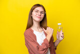 Fototapeta Londyn - Young English woman with a bottle of water isolated on yellow background proud and self-satisfied