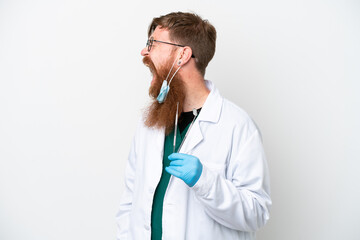 Wall Mural - Dentist reddish man holding tools isolated on white background laughing in lateral position