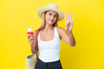 Wall Mural - Blonde Uruguayan girl in summertime holding ice cream isolated on yellow background happy and counting four with fingers
