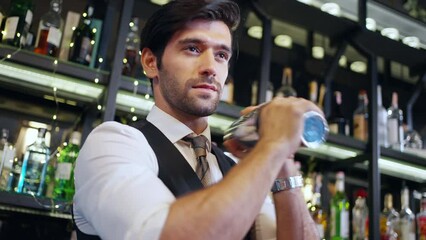 Poster - Handsome man bartender preparing cocktail drink in cocktail shaker serving to customer on counter at luxury restaurant bar. Barman making mixed alcoholic drink celebrating holiday party at nightclub