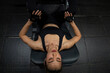 © supAVADEE BUTRADEE - Asian woman trainer wearing sports bra exercising in gym using leg strength equipment lying push up apparatus to build leg muscles. Sport, health and fitness concept.