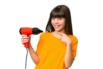 Wall Mural - Little Caucasian girl holding a hairdryer over isolated background and pointing it