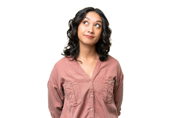 Young Argentinian woman over isolated background and looking up