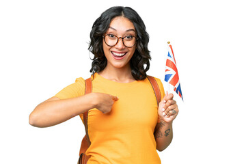 Wall Mural - Young Argentinian woman holding an United Kingdom flag over isolated background with surprise facial expression