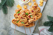 Christmas or New Year appetizer. Christmas tree shape puff pastry buns with cheese and ham. Group of Christmas tree shapes on marble stand. Festive idea for Christmas or New Year dinner. Top view.