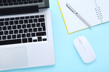 Poster - Laptop computer with notepad and mouse on blue background