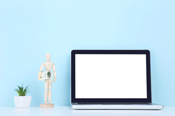 Poster - Laptop computer with wooden figure and dollar banknotes on blue background