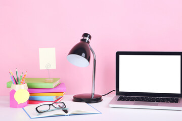 Poster - Laptop computer with books, pencils and electrical lamp on pink background