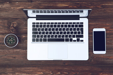 Poster - Laptop computer with smartphone and green cactus on wooden table