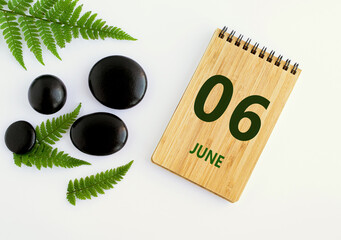 Wall Mural - June 06. 06th day of the month, calendar date. Notepad, black SPA stoneJune s, green leaves. Summer month, day of the year concep