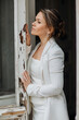 © andrey - a beautiful, confident woman in a white suit at the old window. image of bride