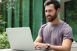 © New Africa - Handsome man with laptop in outdoor cafe