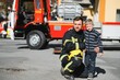 © Serhii - Fireman (firefighter) in action standing near a firetruck. Emergency safety. Protection, rescue from danger.