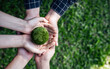 Top View Hands of People Embracing a Handmade Globe for Protecting Planet Together in World Earth Day Concept. Green Energy, ESG, Renewable, and Sustainable Resources. Environmental Care.
