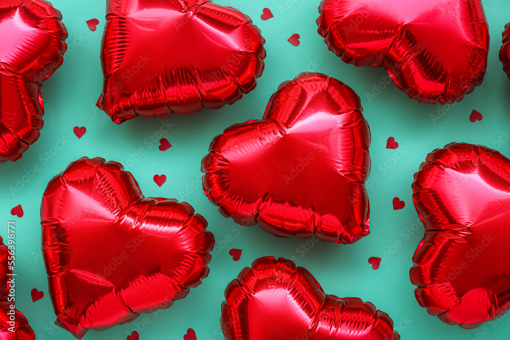 Red heart-shaped balloons on green background. Valentine's Day celebration
