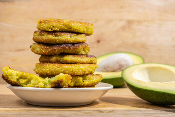 Wall Mural - Avocado Corn Fritters or Latkes on wooden background.