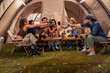 © Kawee - Group of diverse friend having outdoors camping party together in tent.