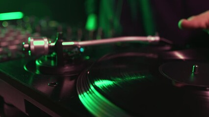 Wall Mural - Dj turntable playing vinyl record with music on a party in night club. Professional disc jockey audio equipment filmed in close up