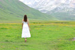 © Antonioguillem - Back view of a woman in white dress walking in the mountain