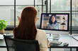 © Prathankarnpap - Back view of businesswoman discussing issues remotely online via videoconference app on computer