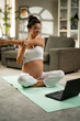 © JustLife - Beautiful pregnant woman practising yoga at home. Woman doing stretching exercise