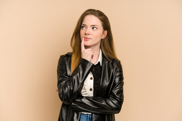 Young redhead woman cut out isolated looking sideways with doubtful and skeptical expression.