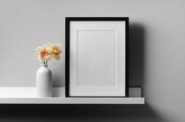 Wooden frame mockup on shelf over grey wall with flowers in vase, blank vertcal frame with copy space