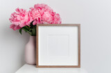 Fototapeta  - Wooden square frame mockup with pink peony flowers in white room interior
