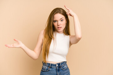 Wall Mural - Young redhead woman cut out isolated holding and showing a product on hand.