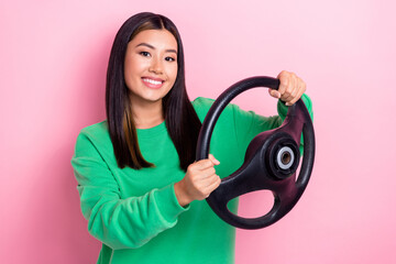 Sticker - Photo of young positive experienced taxi driver chinese girl hold steering wheel new car owner automobile license isolated on pink color background