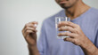 © anut21ng Stock - man with glass of water taking pills