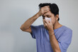 © anut21ng Stock - Portrait Of Sick Asian man covering his mouth and nose with a tissue